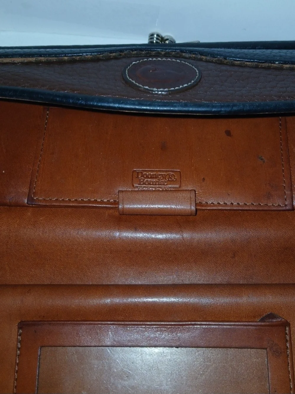 The Dooney & Bourke Black Brown Leather Kisslock Framed Credit Card Trifold